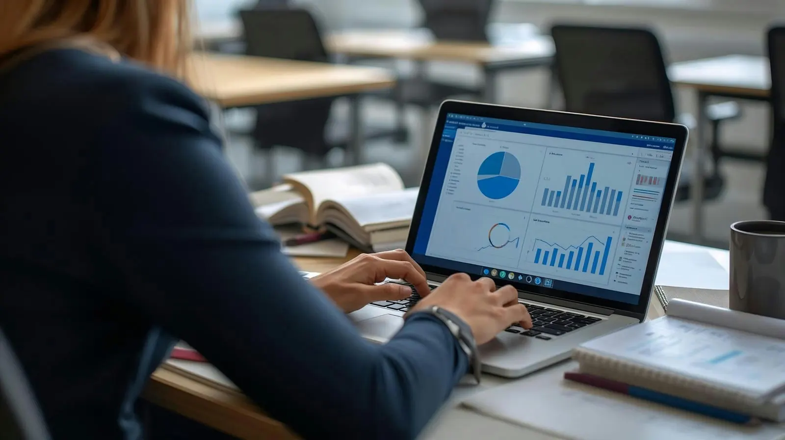 Dizüstü bilgisayarda grafik ve raporlarla çalışan bir kişi