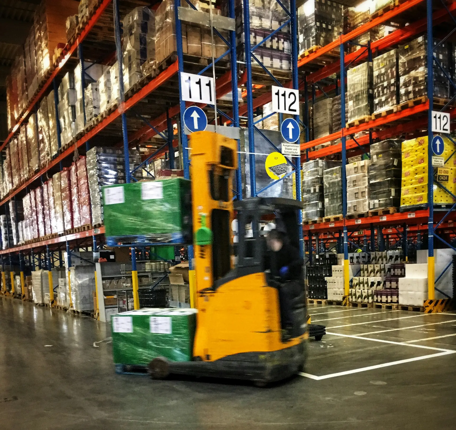 Paletli ürünlerin bulunduğu bir depoda forklift